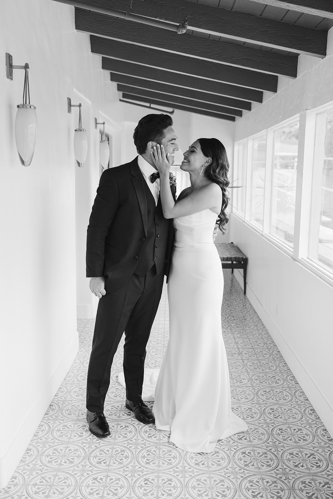 bride and groom portrait as they smile at each other 