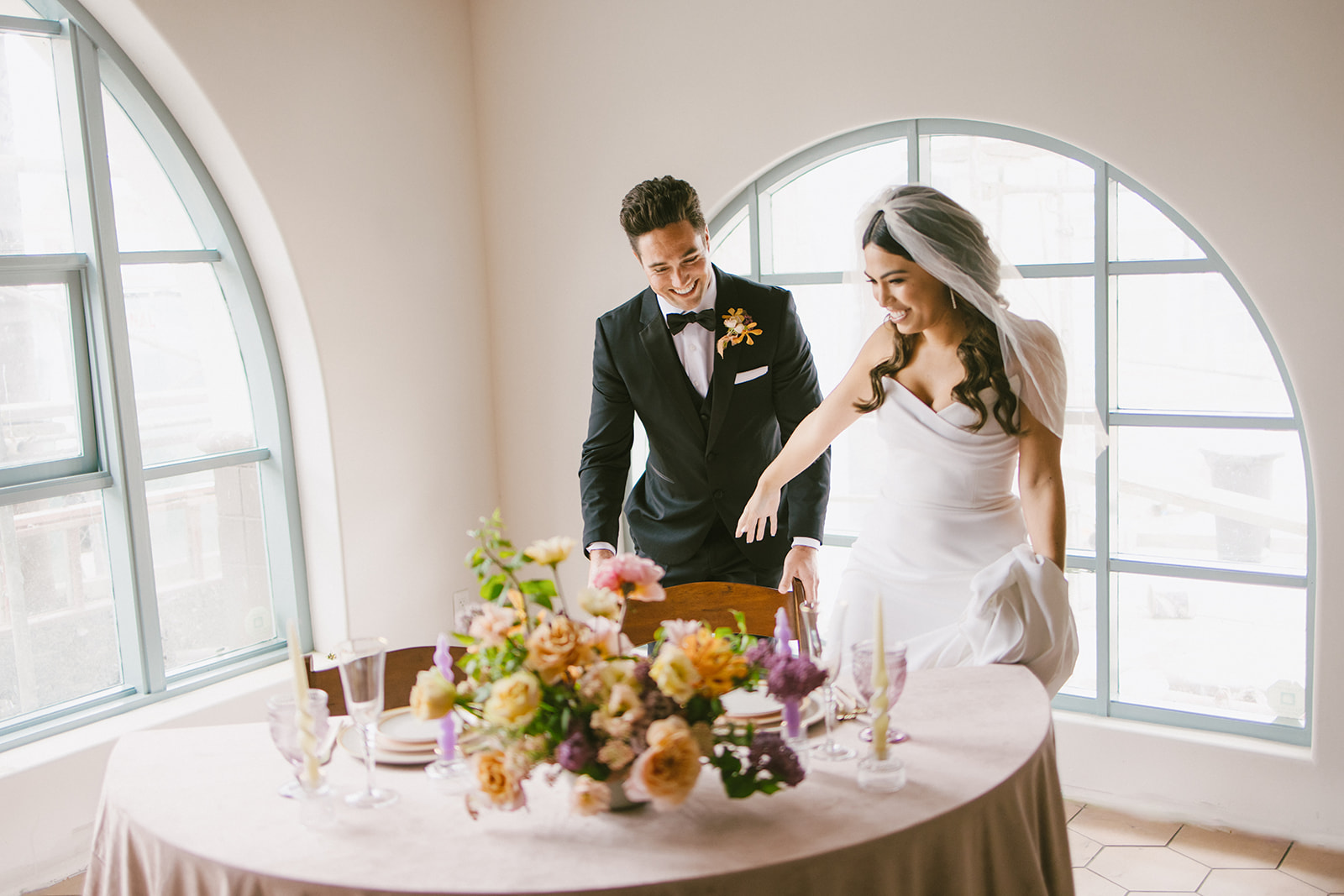 groom pulling the seat out for the bride to sit at head table at San Clemente Wedding Venue