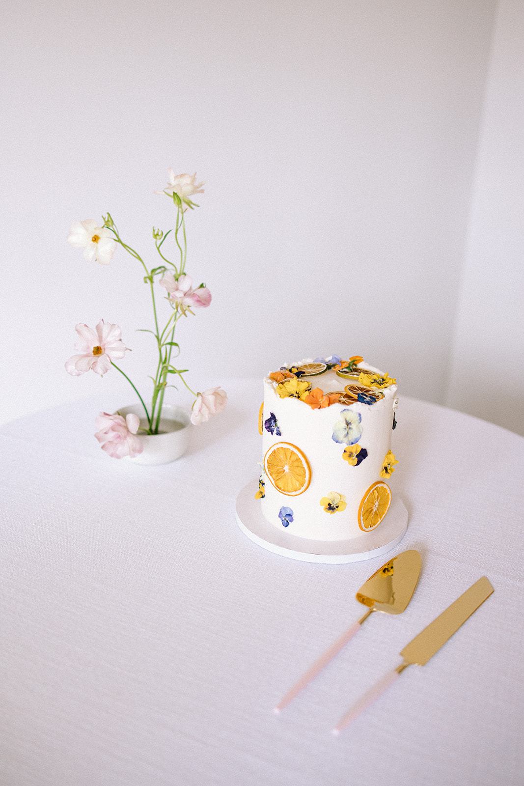 white wedding cake decorated with dried fruit and flowers