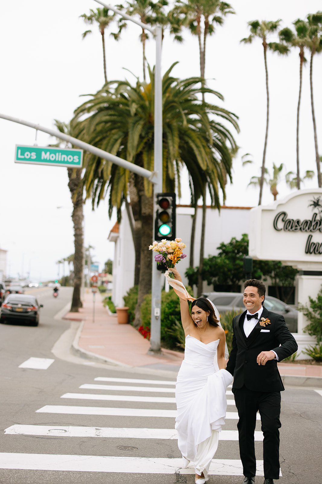 bride and groom walking down a crosswalk in southern california 