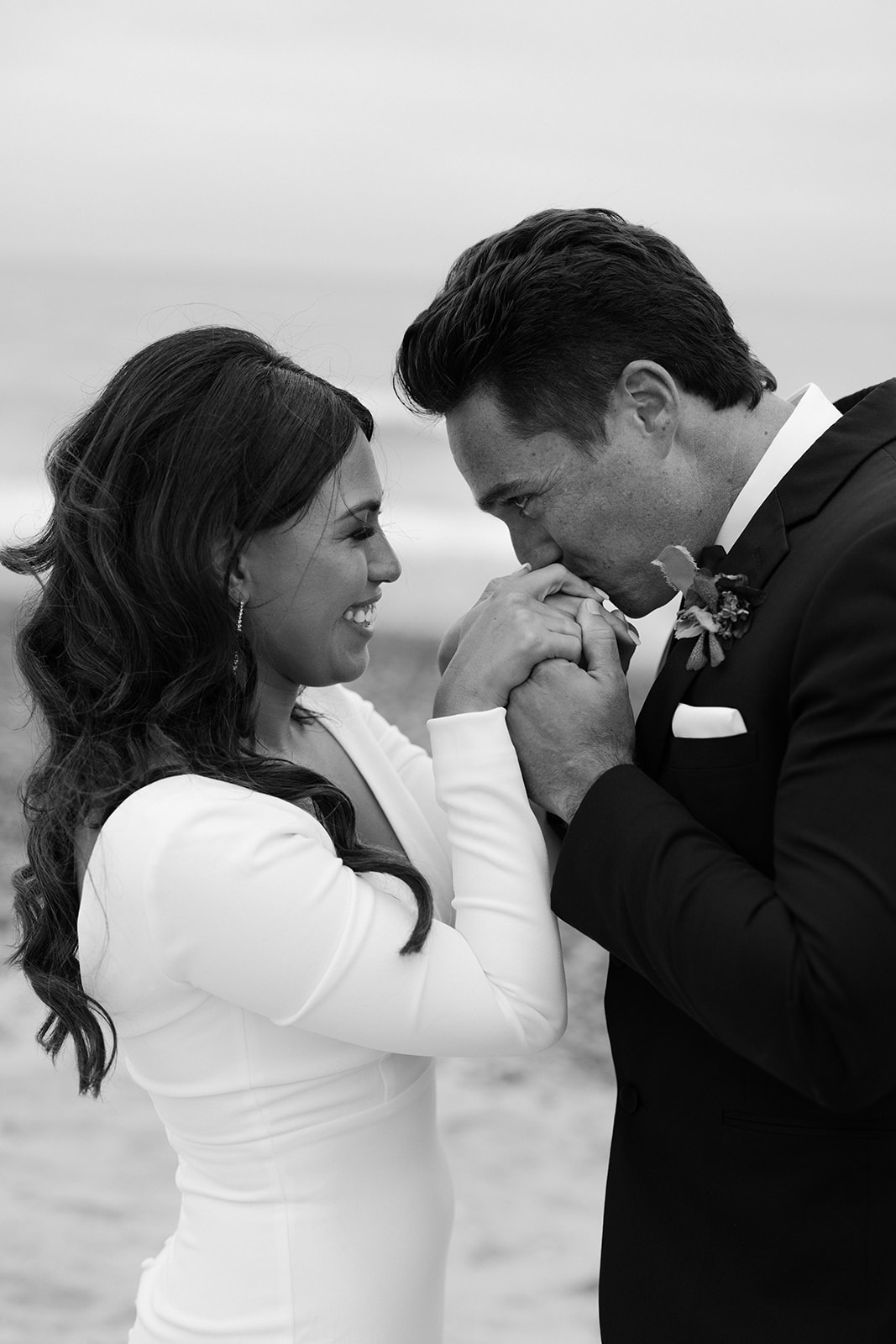 groom holding and kissing bride's hands 