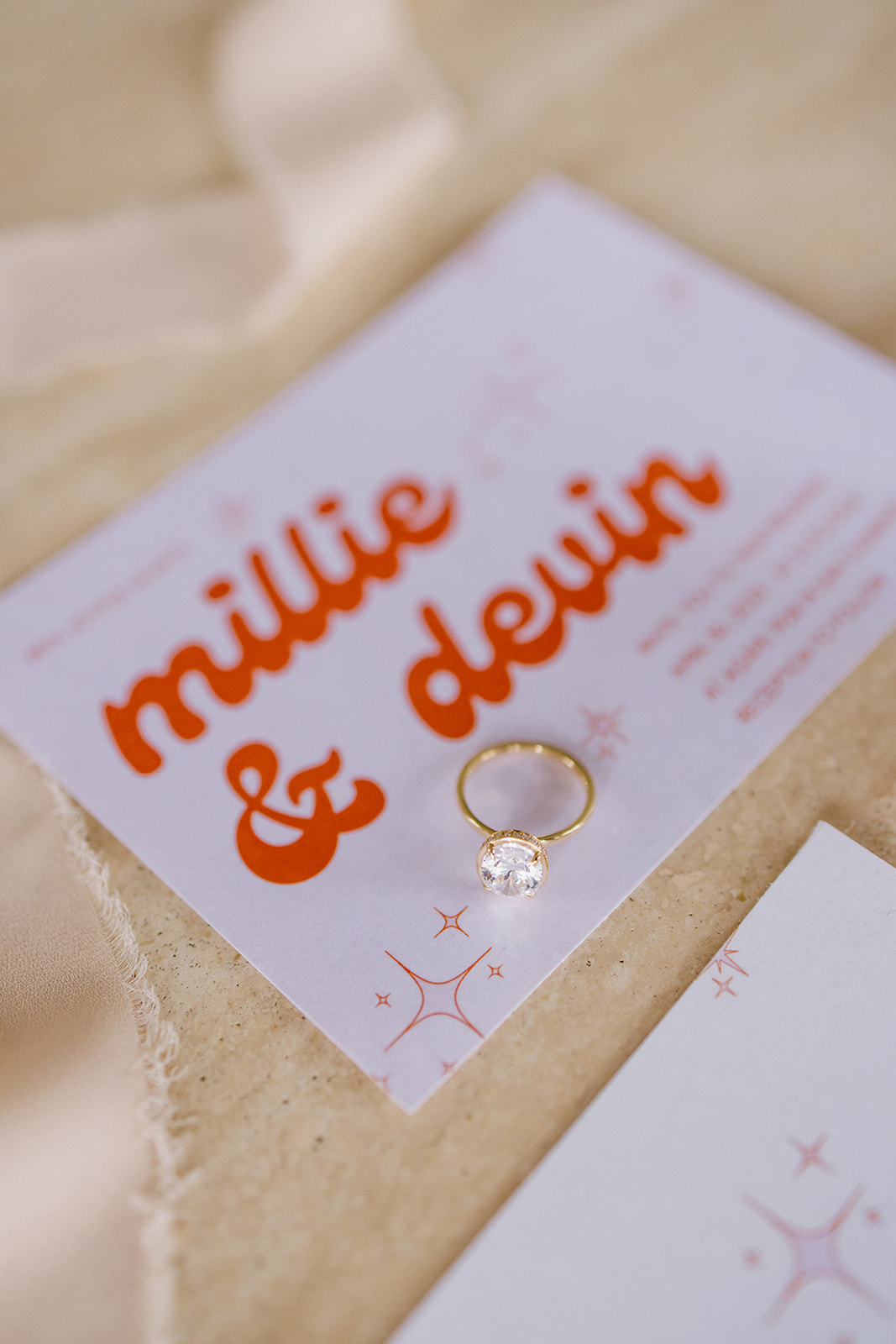 wedding ring on top of wedding invitation