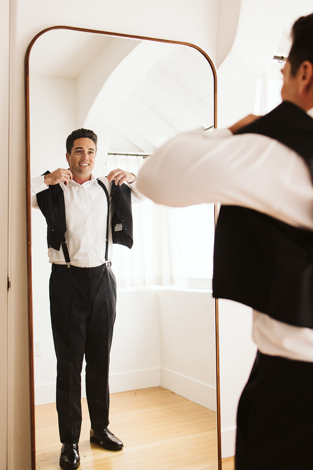 groom looking into the mirror as he gets ready at San Clemente Wedding Venue