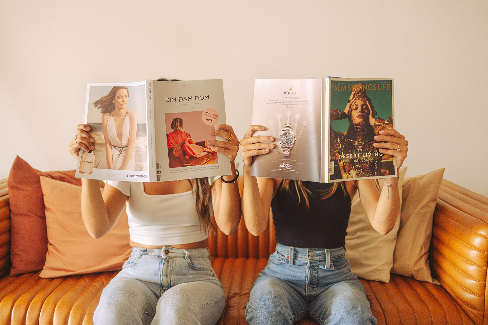 two business owners sitting on a couch holding up magazines during Small Business Branding Photography session