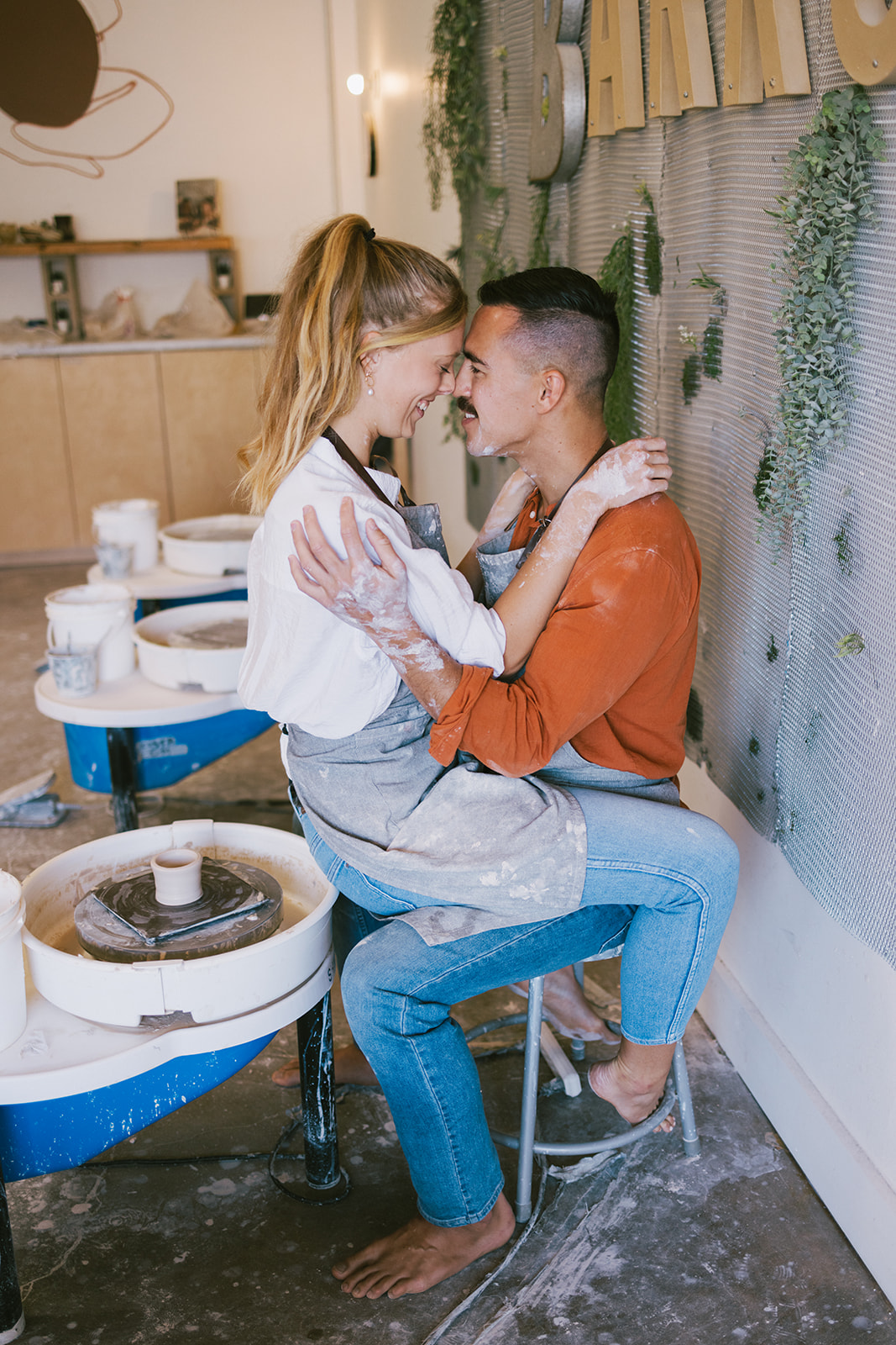 a woman sitting on a mans lap and smiling together 