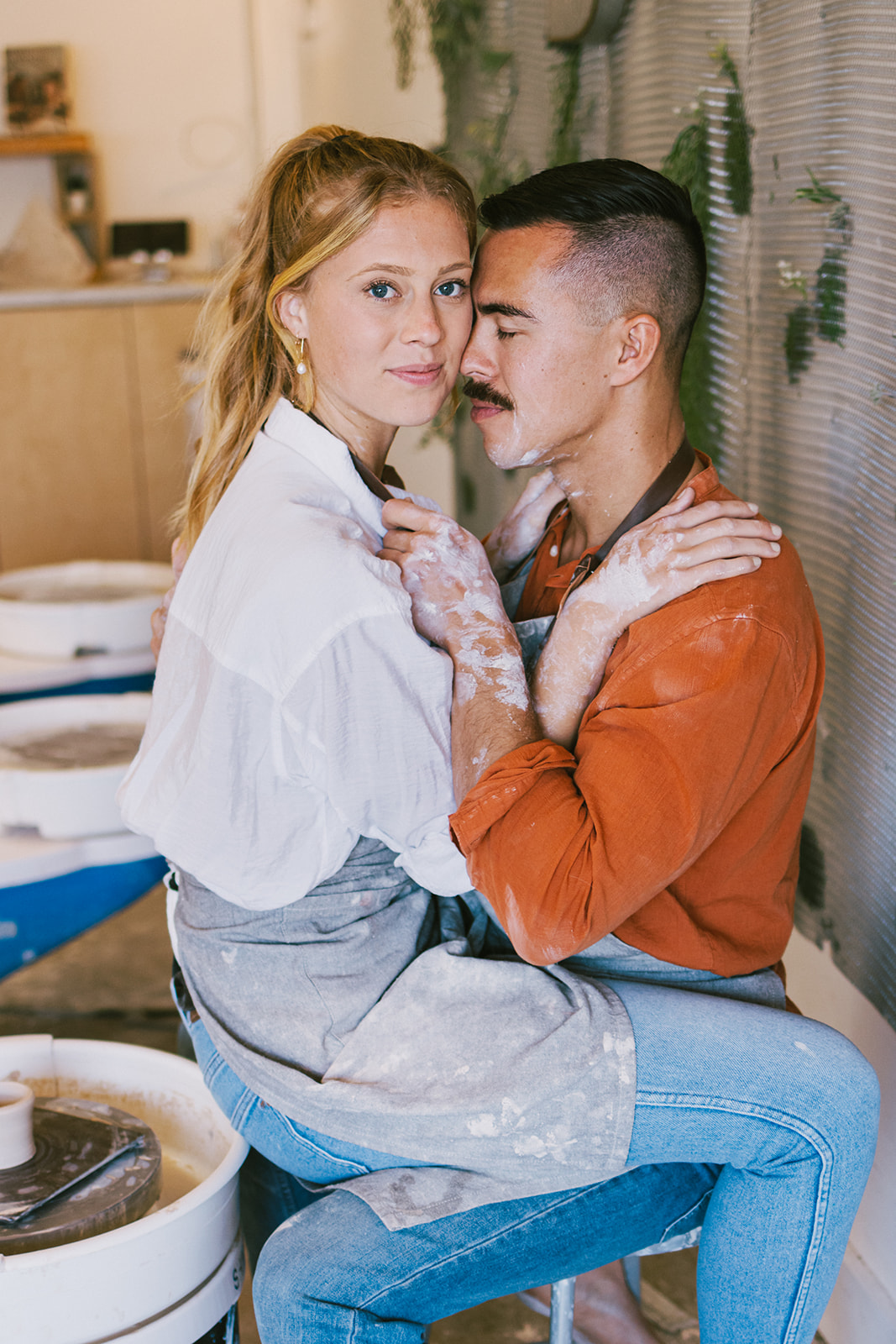 a couple sitting together at a pottery class for their date night photoshoot 