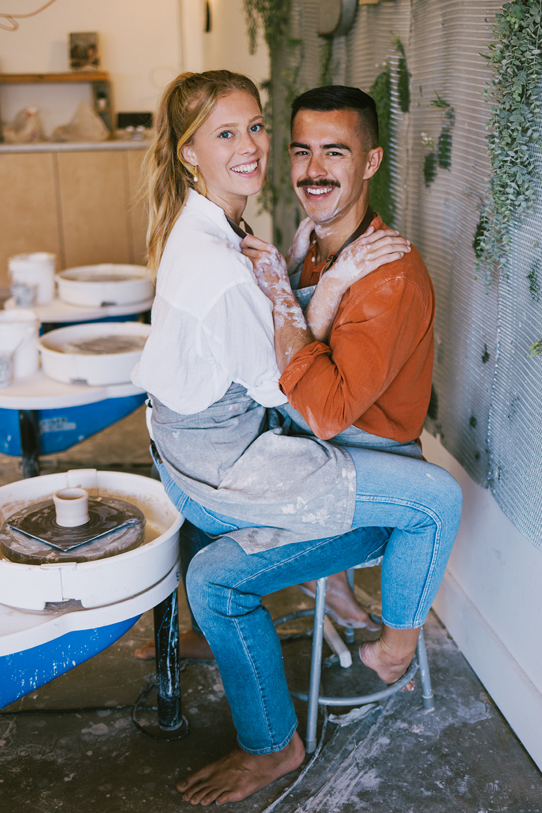 a couple smiling at the camera during their date night photoshoot 