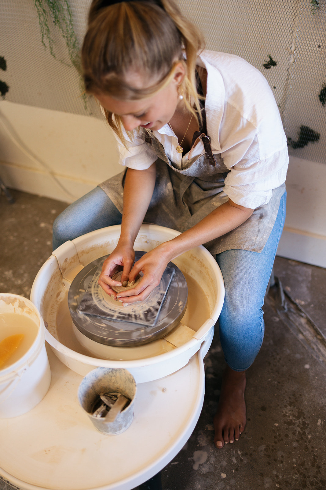 a woman making pottery on a wheel during a date night photoshoot 