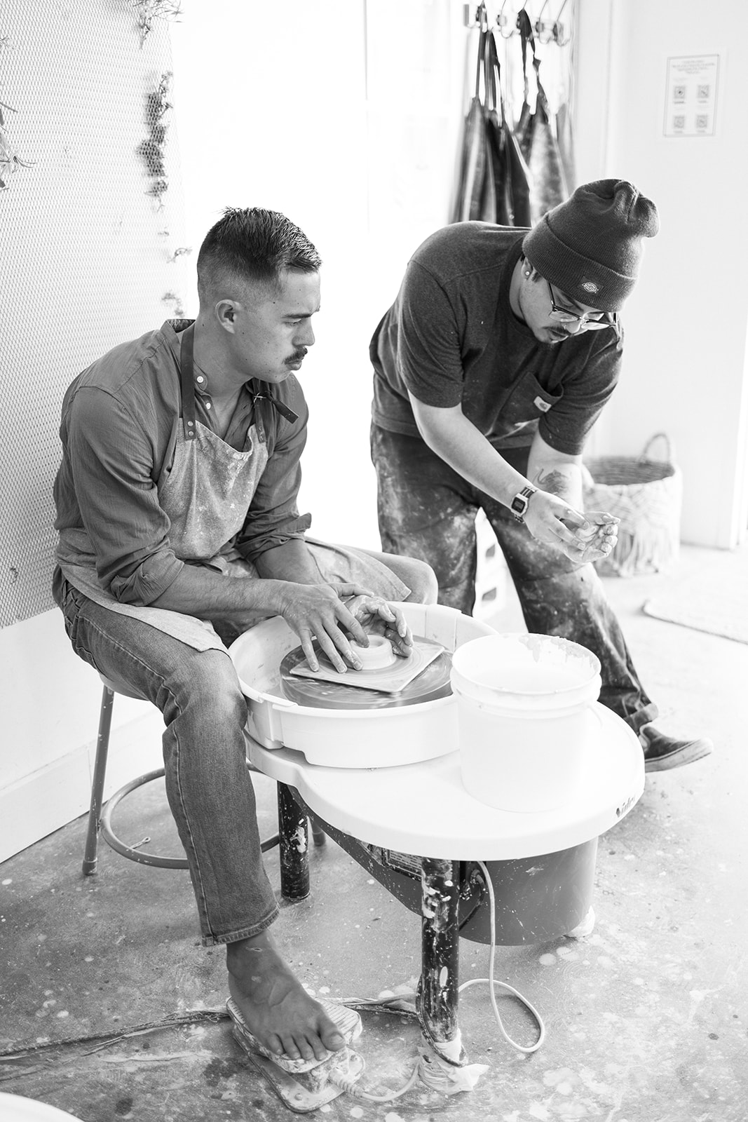 a man getting help while making pottery during a date night photoshoot 