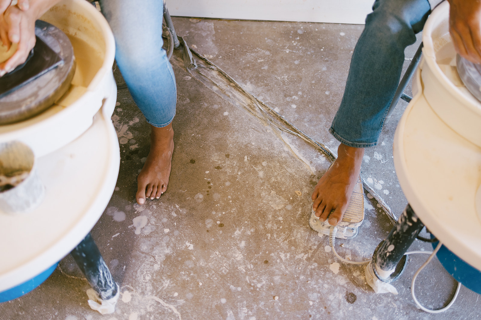 a couple's feet as they make pottery during a date night photoshoot 