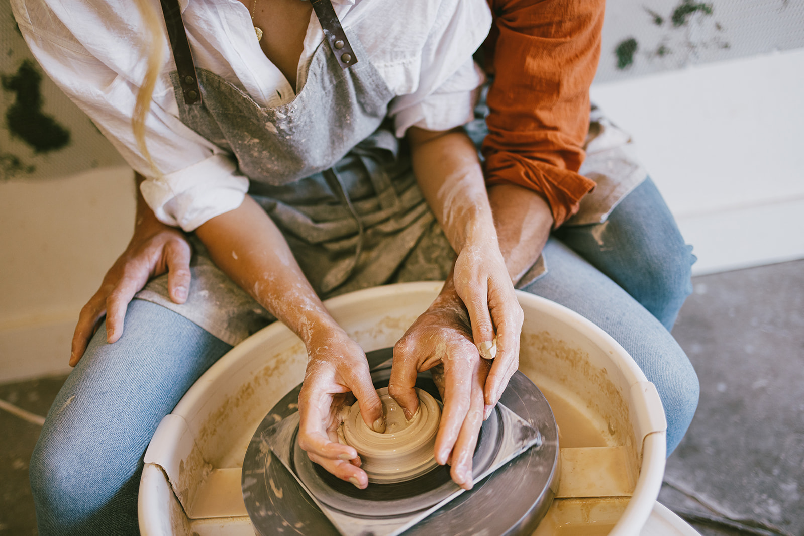 a close up of a couple's hands as they make a pot 