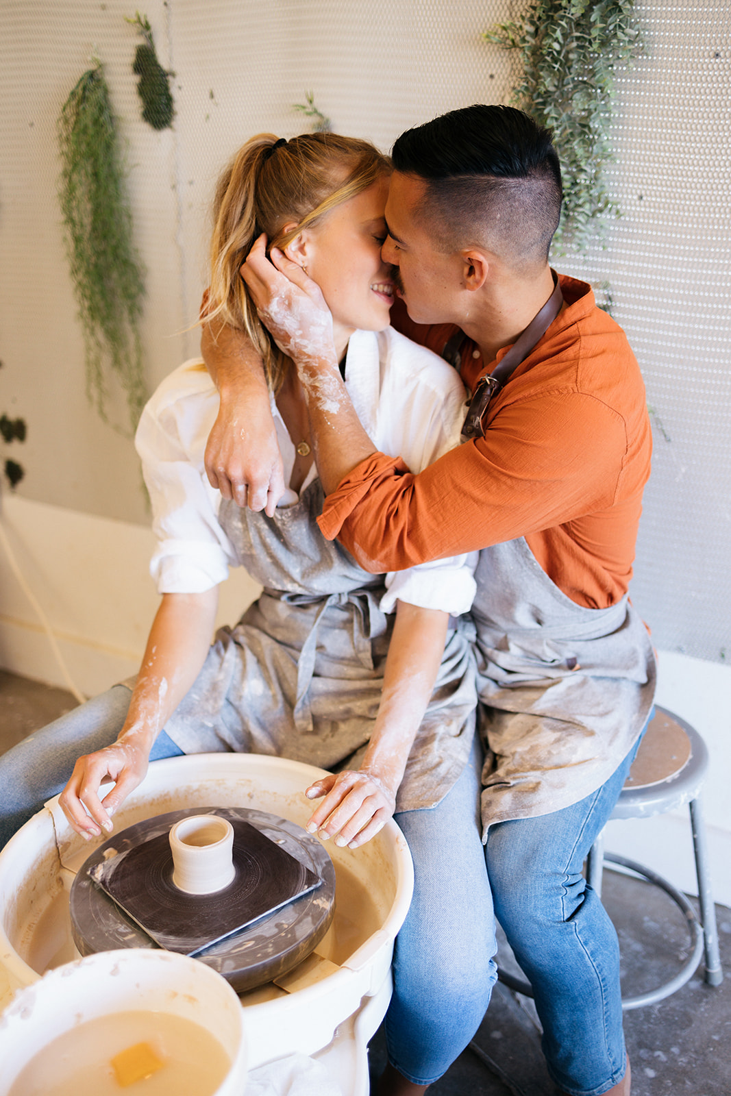 a couple kissing at the pottery wheel 