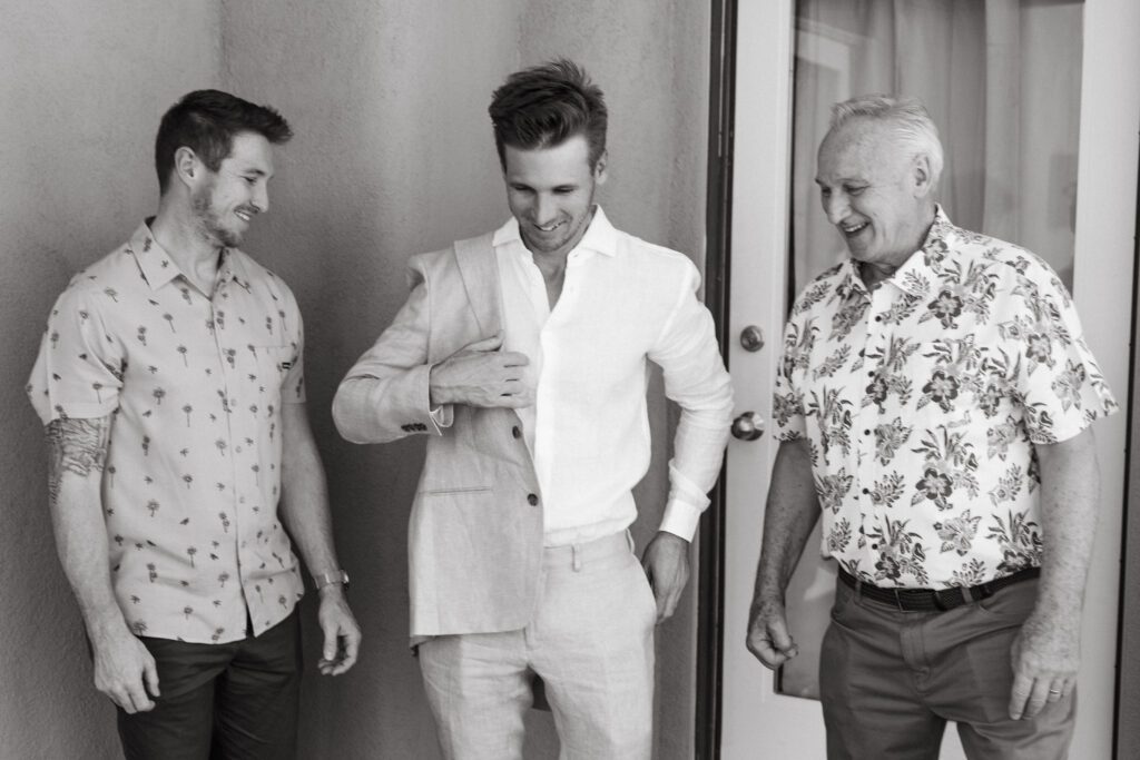 groom and two other men laughing as he gets ready for his Palm Springs wedding 