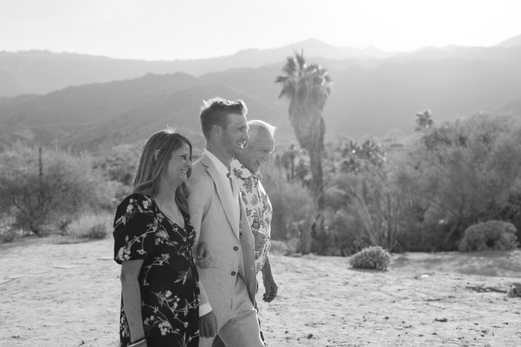 groom and his parents walking down the aisle 