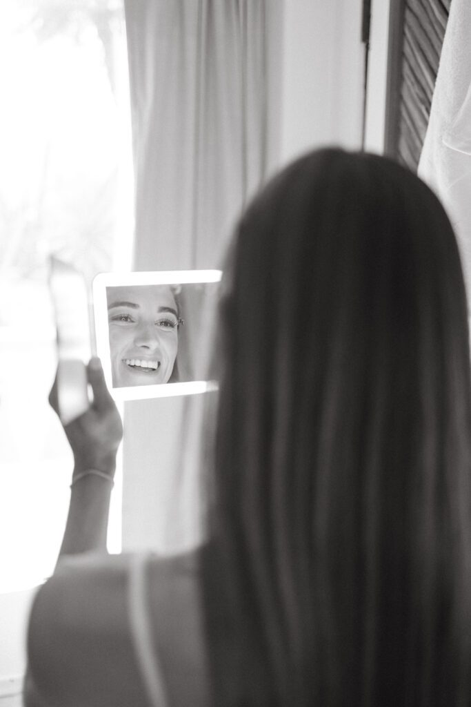 the bride looking into the mirror while getting ready for Palm Springs wedding 