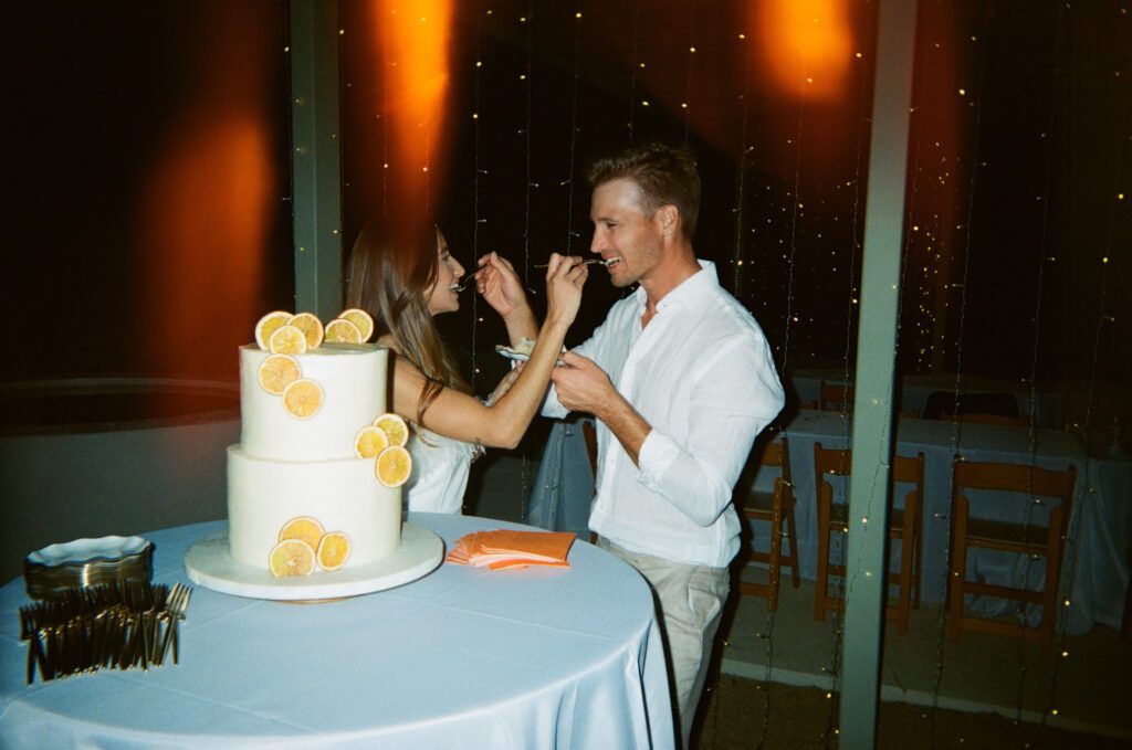 film photo of bride and groom eating cake 