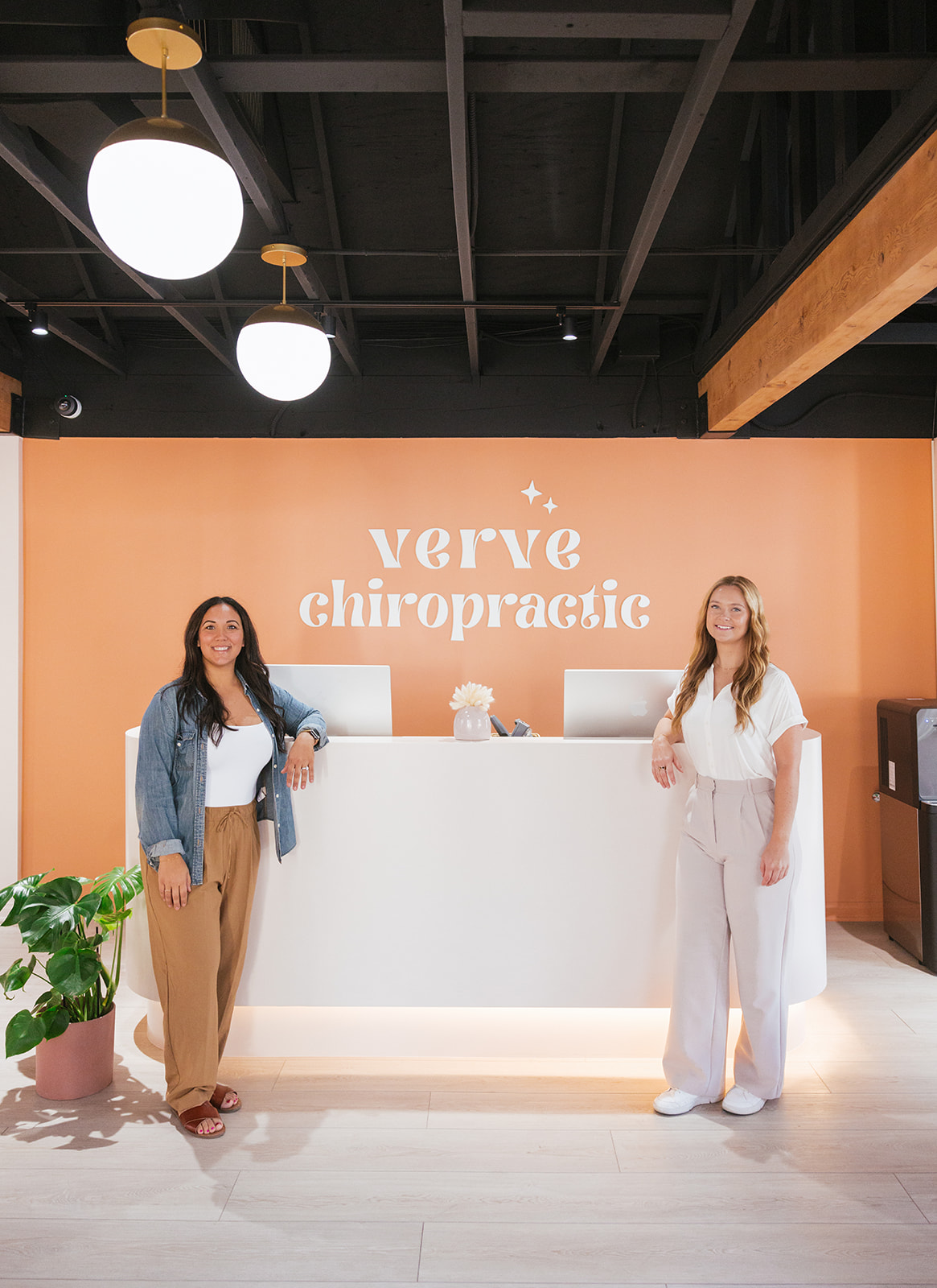 the chiropractors standing at the front desk during a brand photoshoot in SoCal 