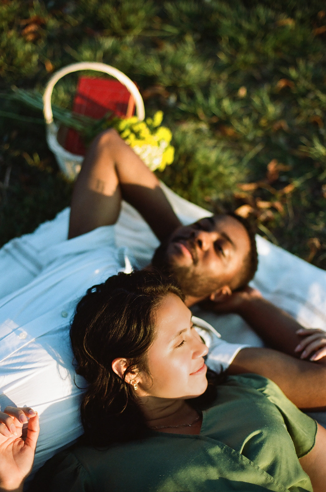 a couple laying on a blanket together in a park