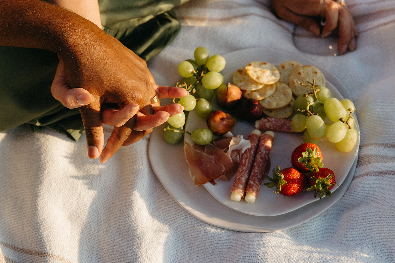 close up of a couple holding hands during their picnic 