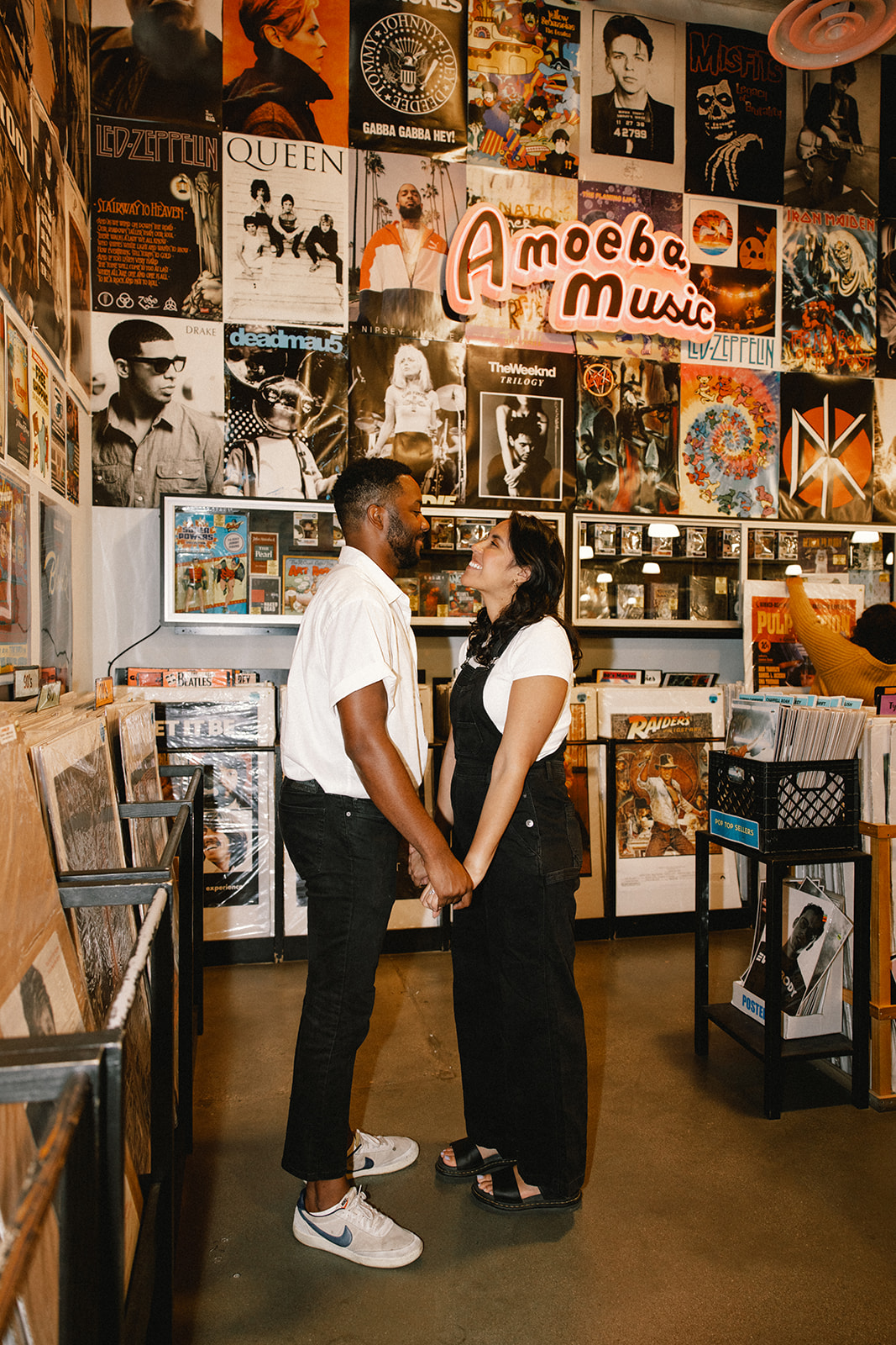a couple holding hands during their fun couples photoshoot at Amoeba Music 