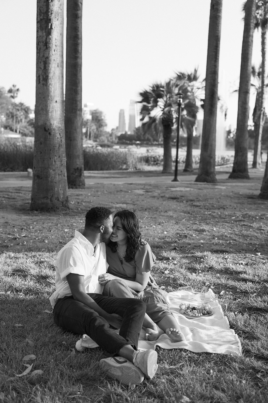 a couple snuggling while on a picnic together 