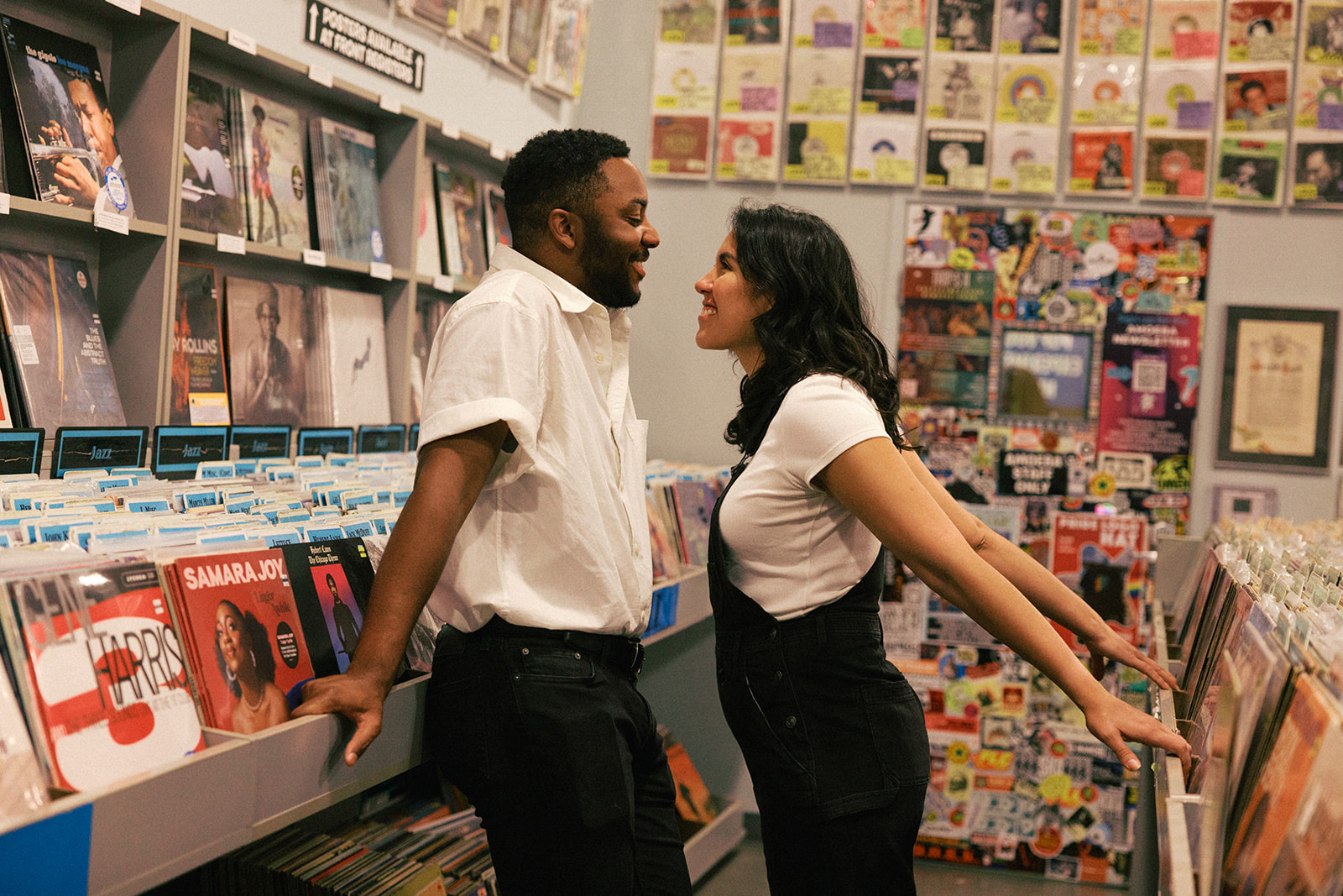 a couple leaning into eachother in the record store 