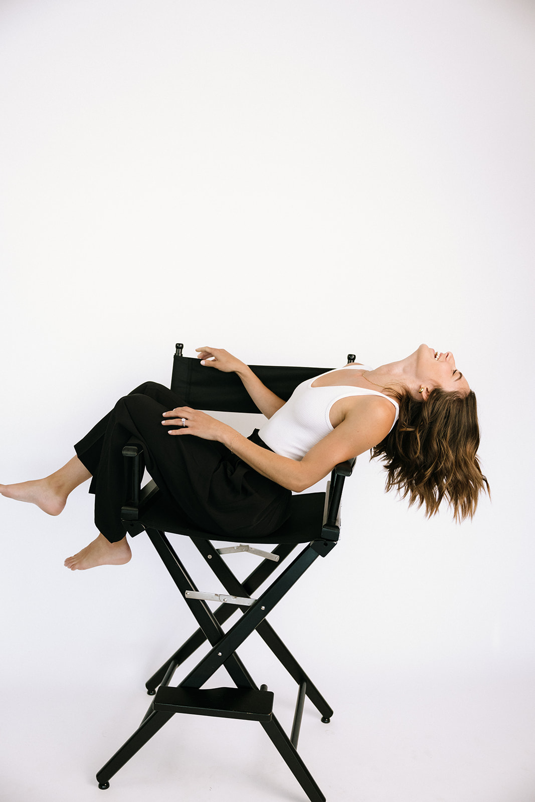 a woman in a chair against an all white backdrop 