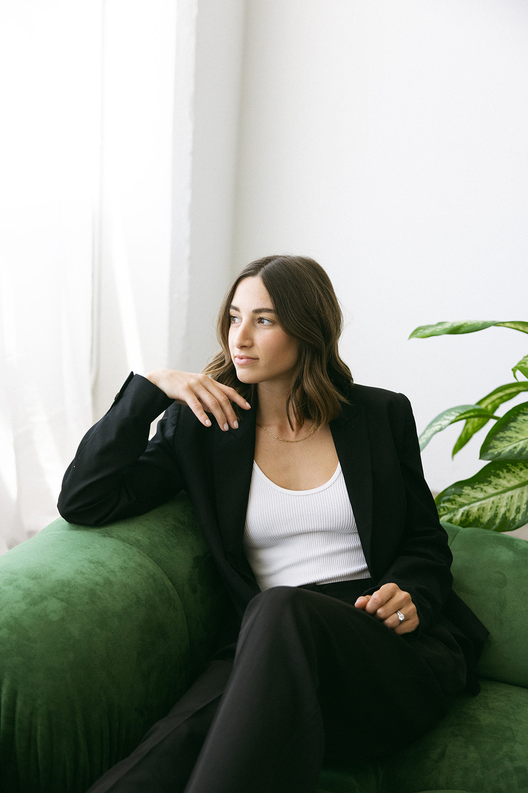 a woman sitting on a green couch in studio for her branding photography session