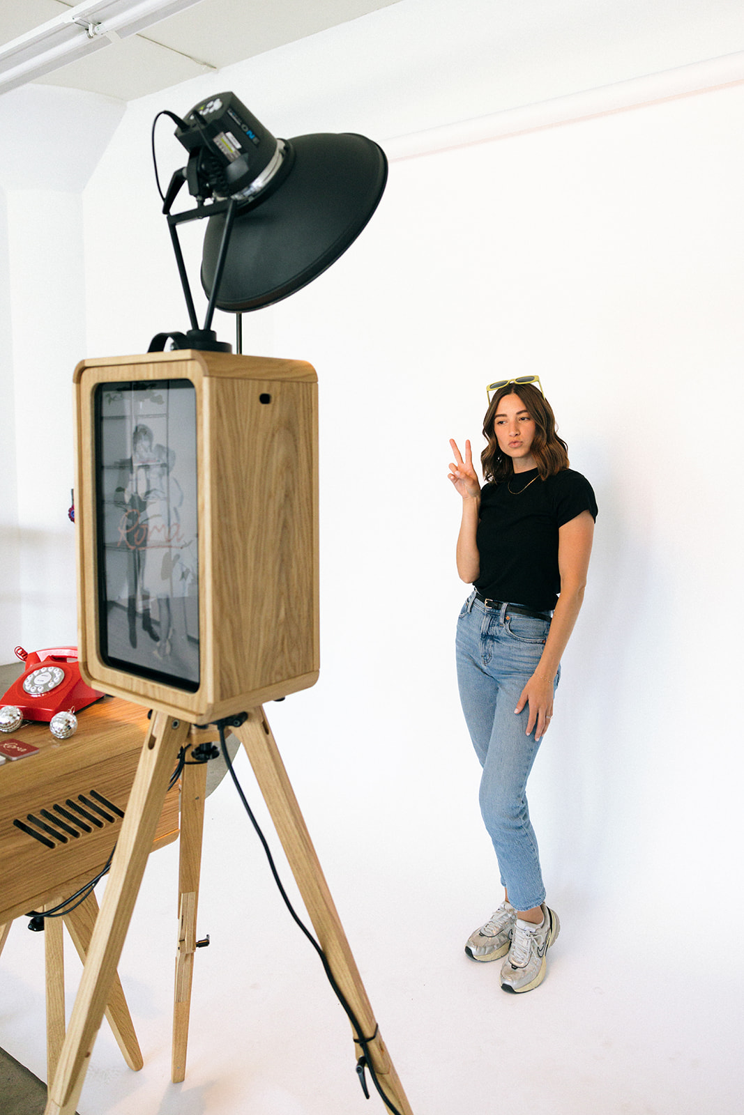 a woman doing the peace sign to the photo booth camera 