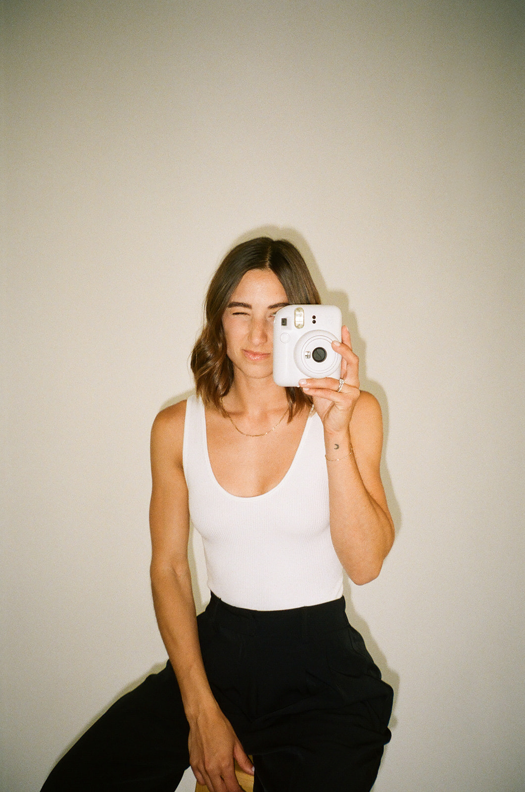 a woman holding up a camera in a 35mm film branding session