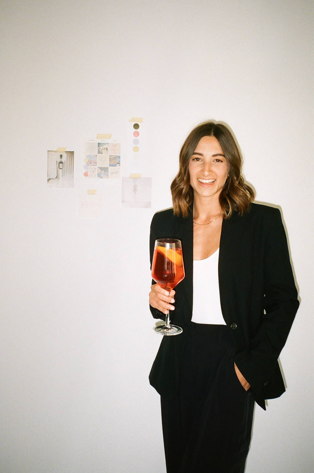 a woman standing in front of her brand materials pinned to the wall 
