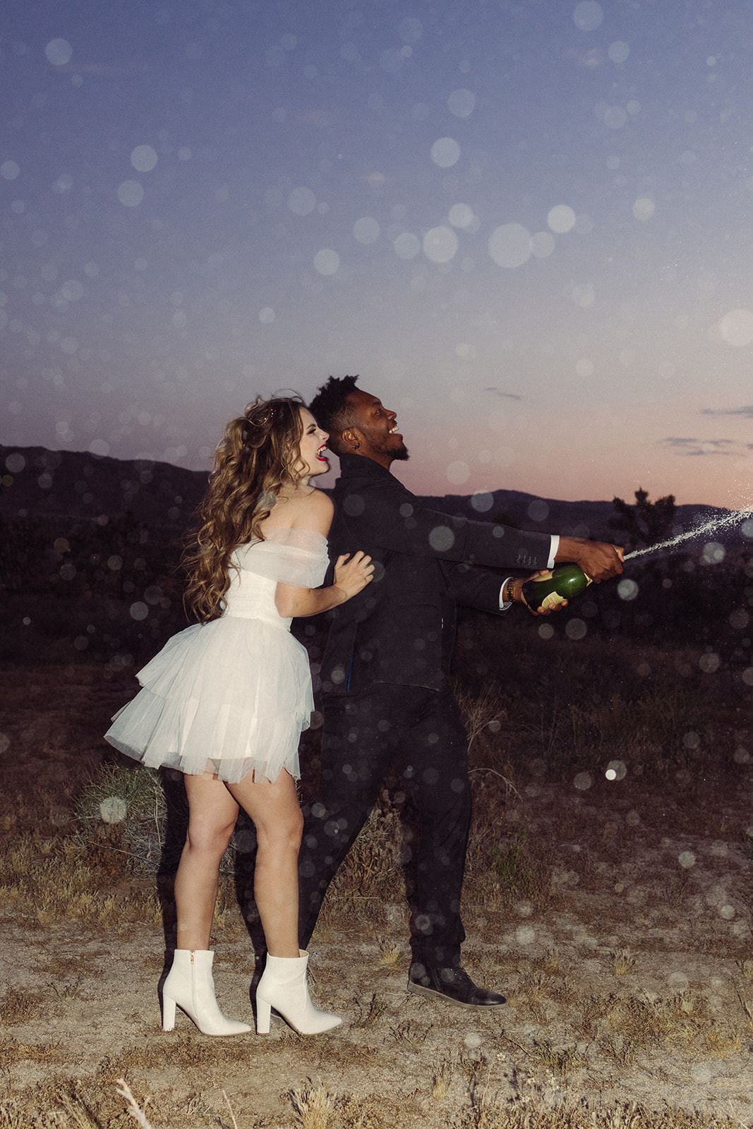 the champagne flying as the couple laughs 