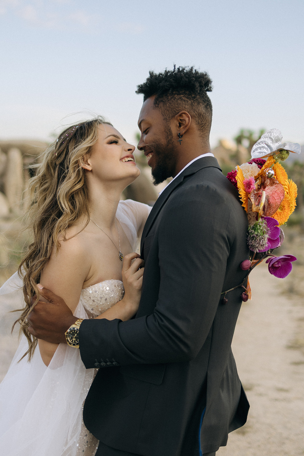 bride and groom laughing as they embrace 