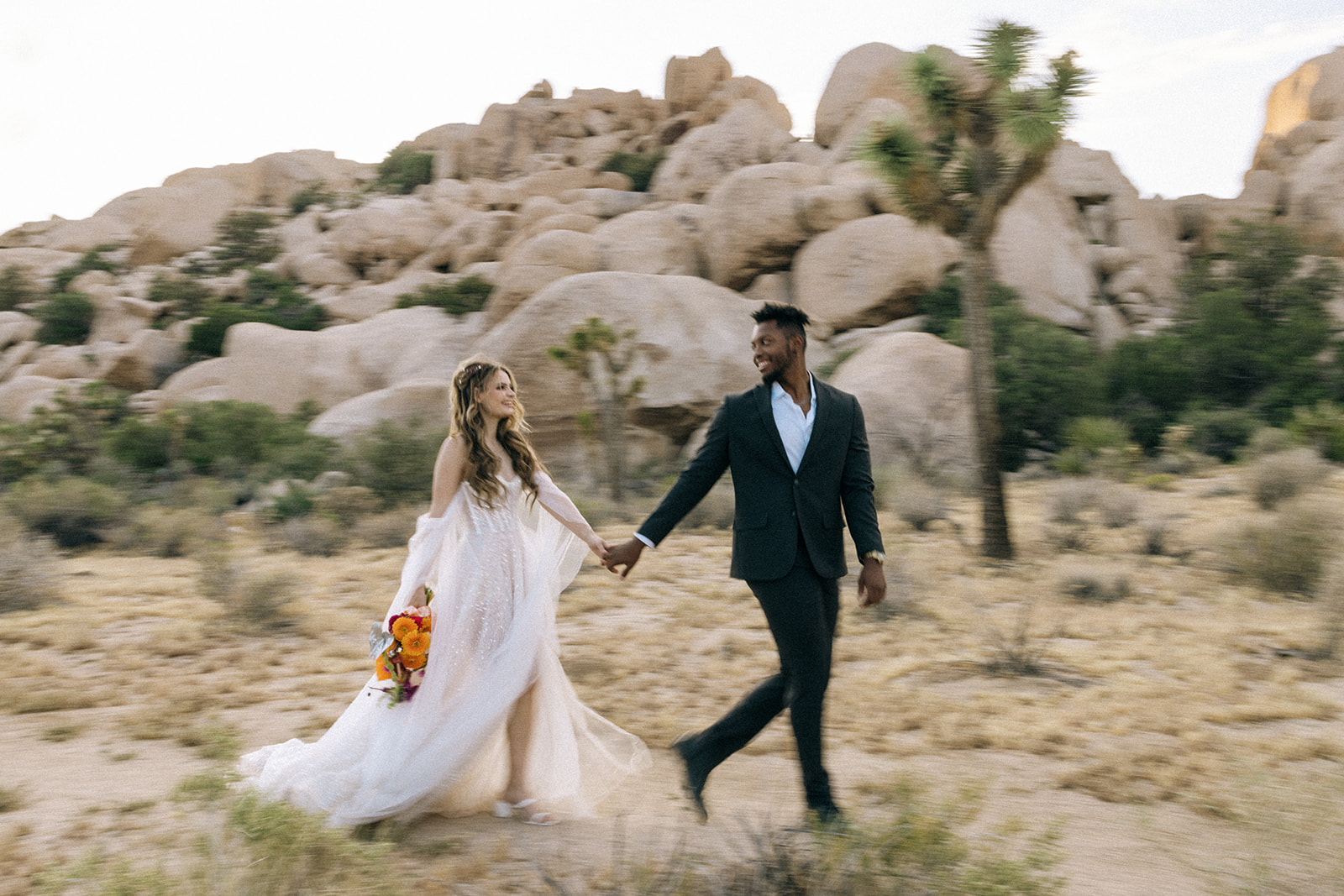 bride and groom holding hands as they walk 