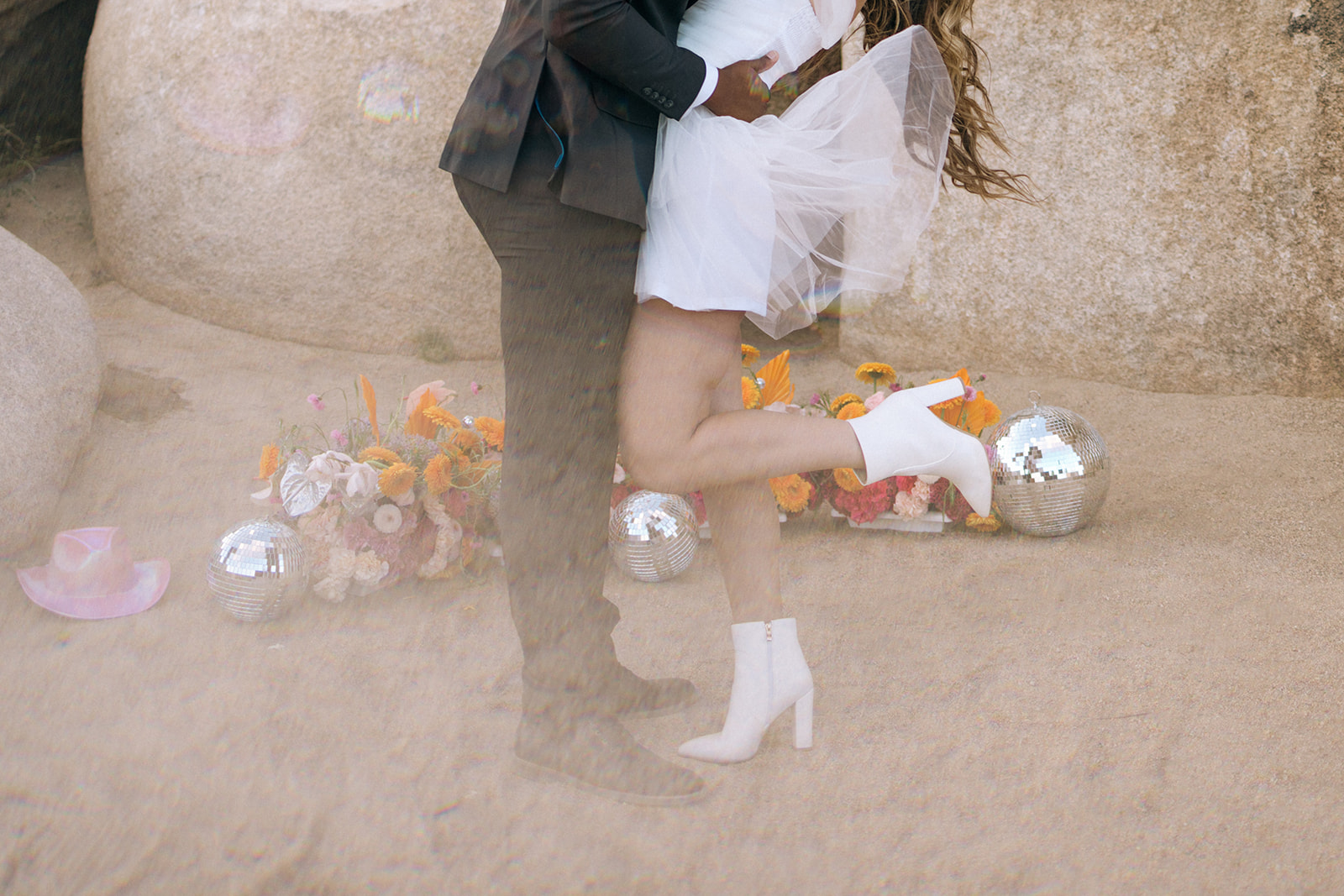 bride and groom's lower halves as they kiss in front of the southern California elopement ceremony set up