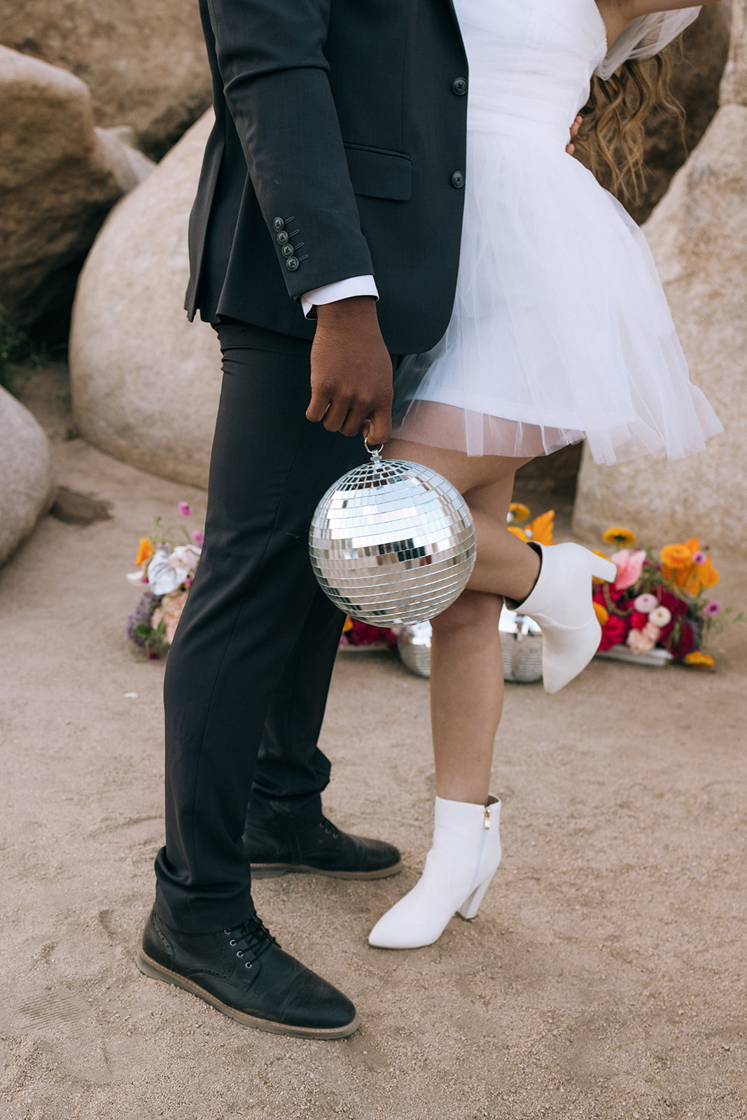 groom holding a disco ball as he embraces the bride during a southern California elopement