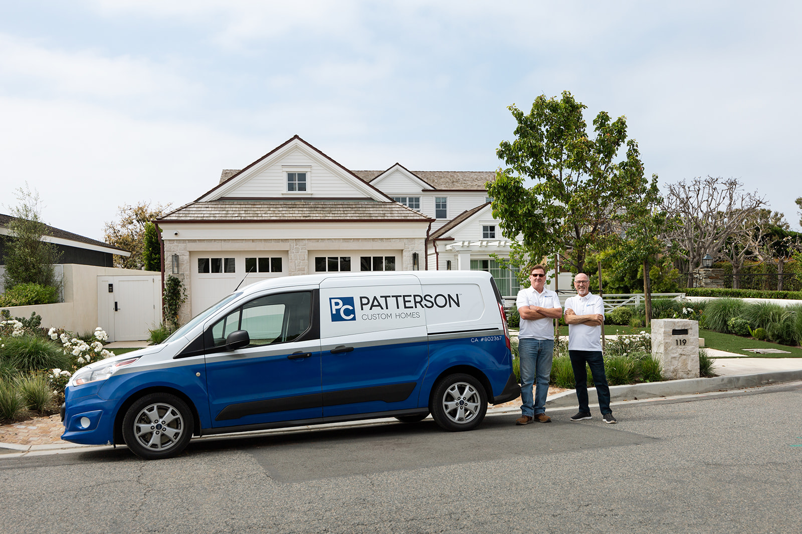 two men standing next to a company car during a California brand photoshoot