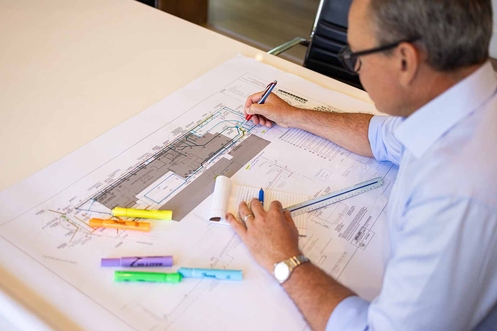 looking over a man's should at design plans during a brand photoshoot