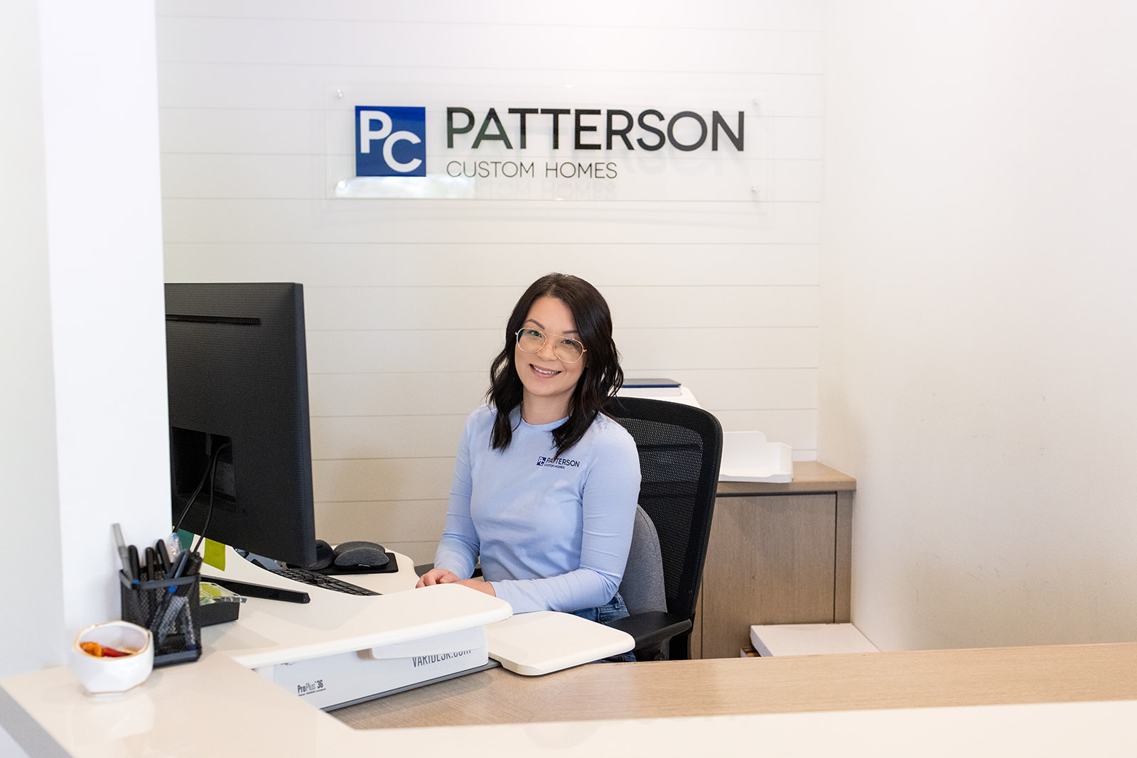 a woman sitting at a desk during a brand photoshoot