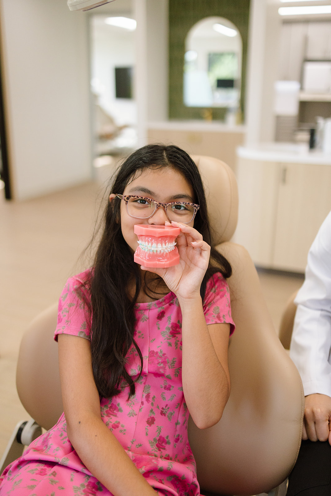 a girl holding up the model of teeth to her mouth 