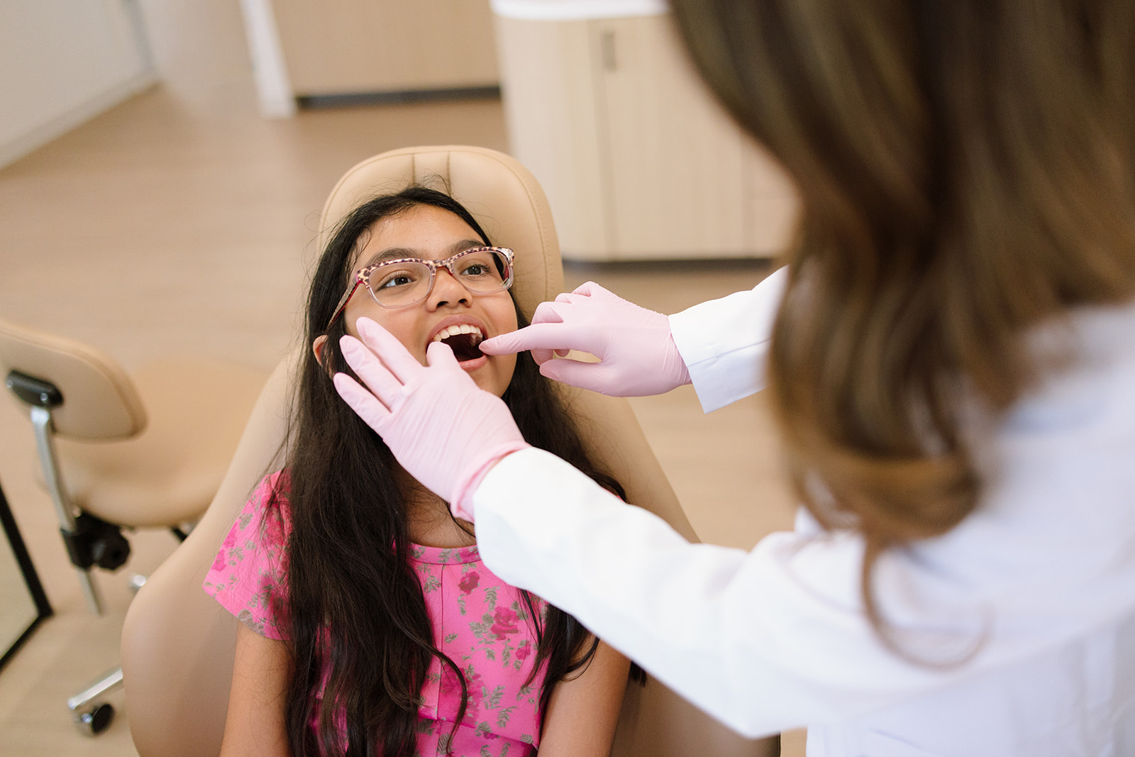 the orthodontist looking at a girl's teeth for branding photos 