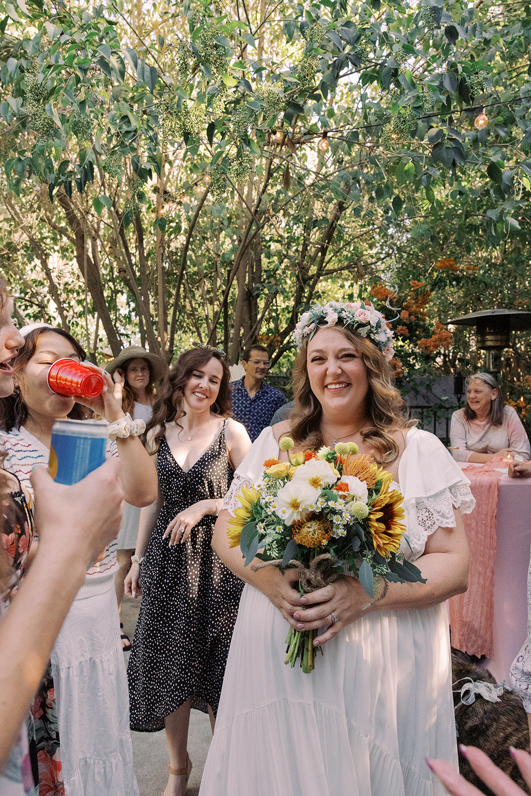 the bride smiling as she holds her flower bouquet 