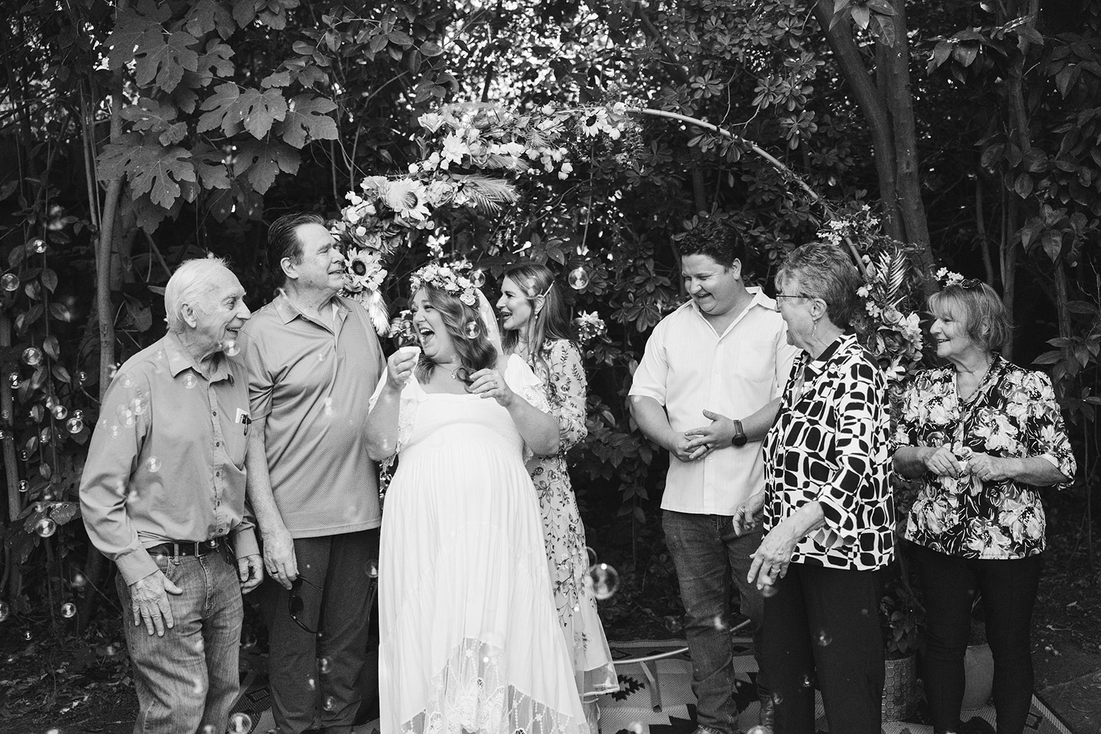 candid wedding photo of the bride and groom and their family 