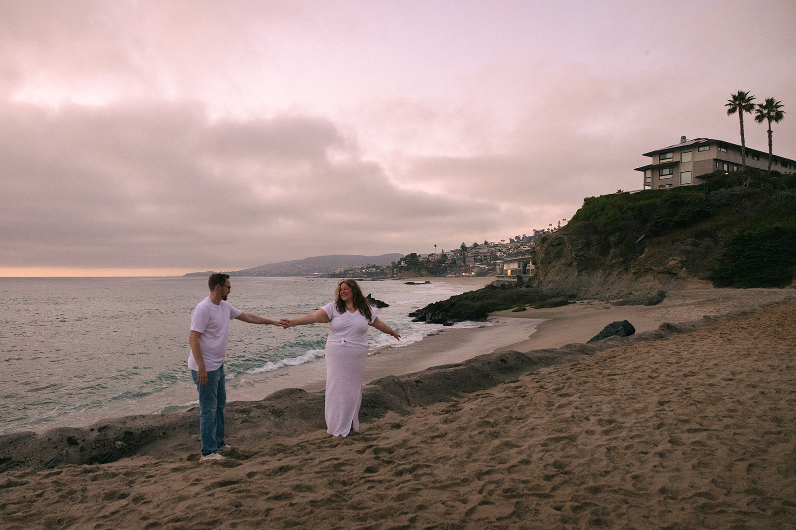 a pink sky during sunset beach engagement photos in California 