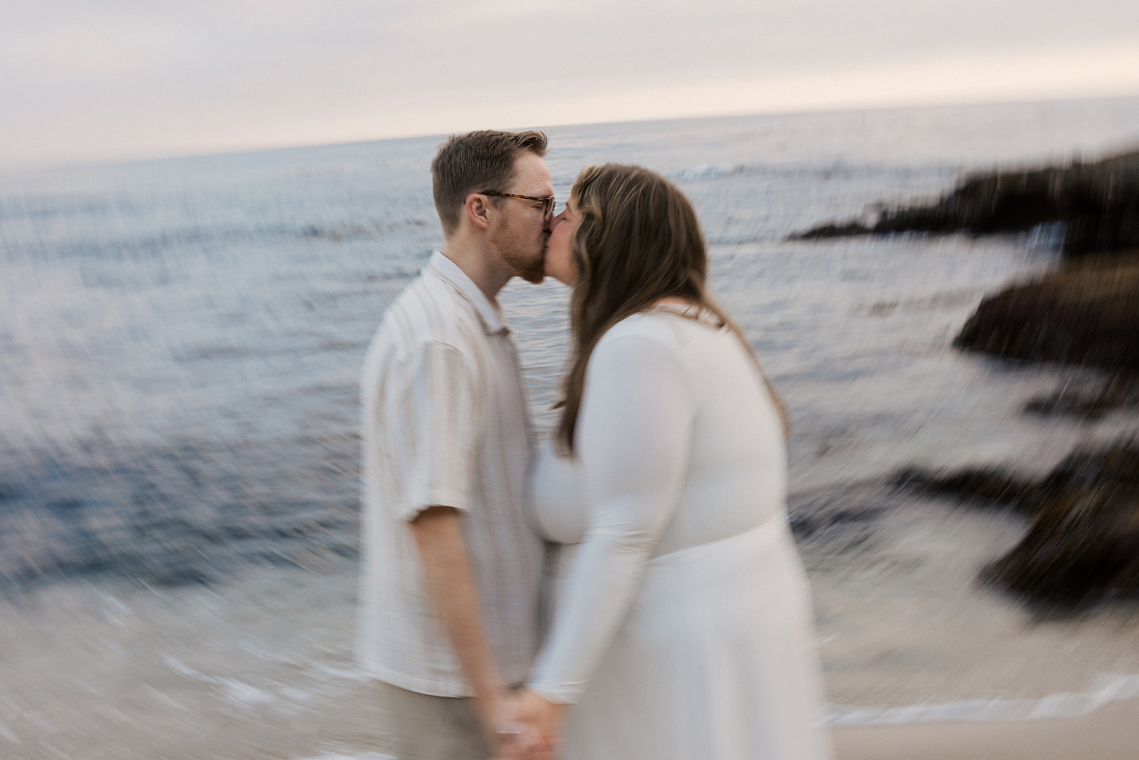 a couple kissing in focus as the rest of the image is blurry 