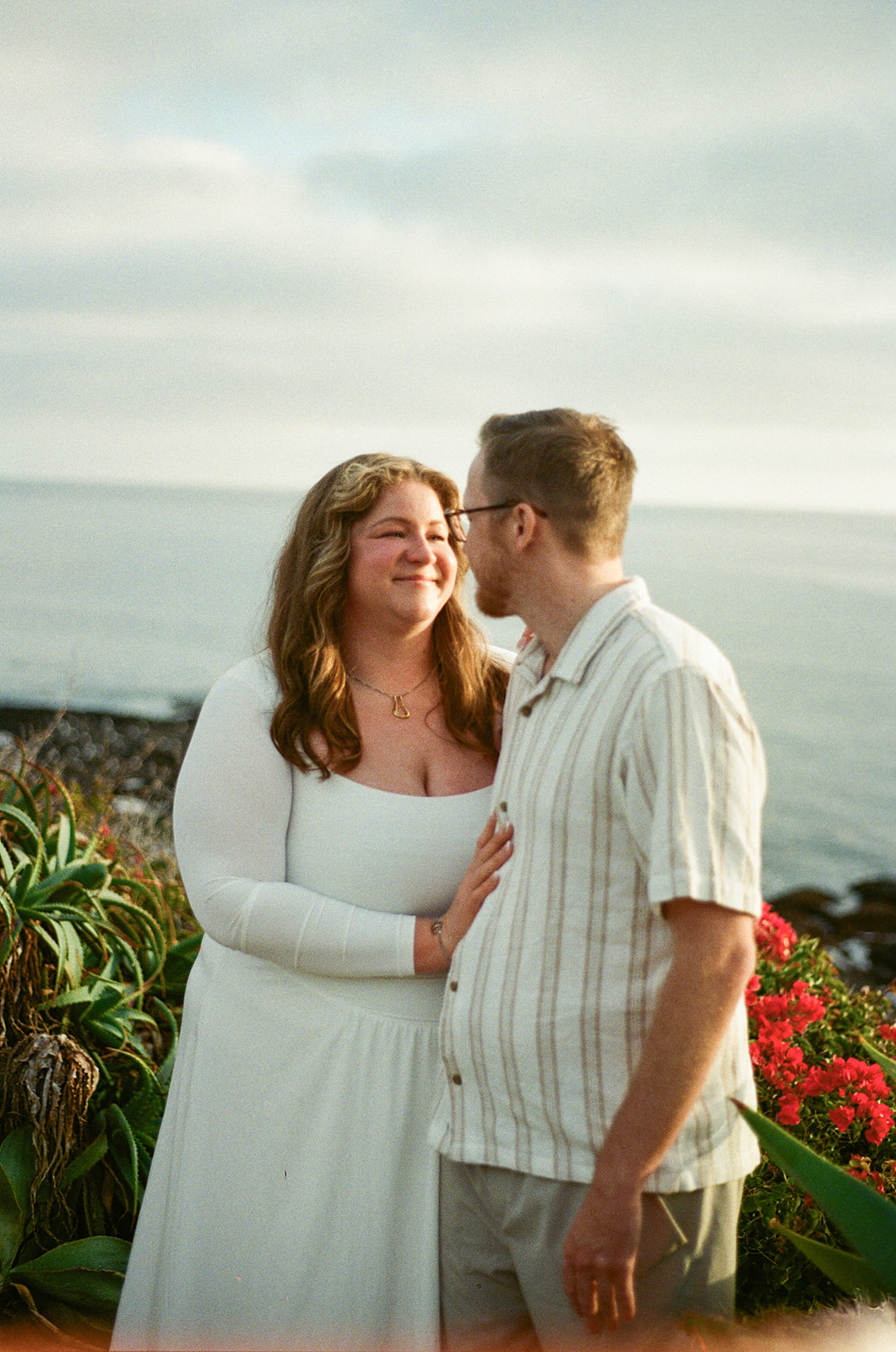 a woman smiling at a man during beach engagement photos in CA